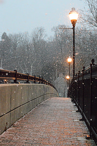 lighted bridge posts under snow during daytime thumbnail