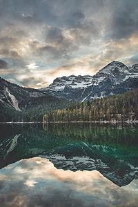 landscape photography of body of water across pine trees and mountain at daytime thumbnail
