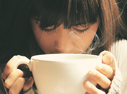 girl in white sweater holding white ceramic cup thumbnail