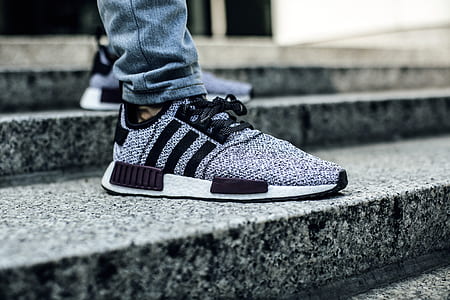 person wearing pair of gray-and-black Adidas NMD_1 shoes thumbnail