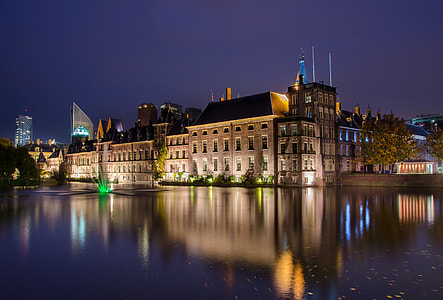 gray concrete building near body of water under purple sky thumbnail
