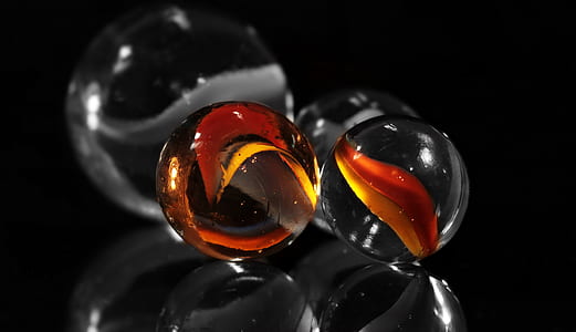 clear marble toys on black surface thumbnail