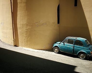 blue Volkswagen Beetle coupe beside building thumbnail