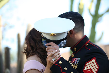 man wearing black marine uniform holding his white cap during daytime thumbnail