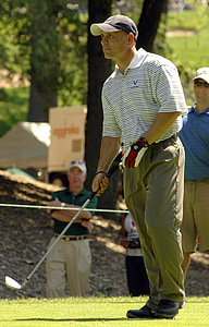 male golf player standing while holding golf club thumbnail