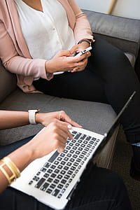 Two Women Using Macbook and Smartphone thumbnail