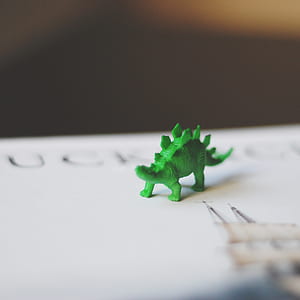 selective focus photography of green dinosaur toy thumbnail