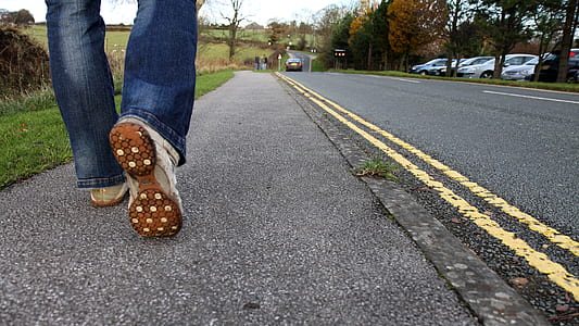 person in blue jeans walking on street during daytime thumbnail
