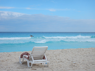 white lounger chair on shore under white clouds and blue sky during daytime thumbnail