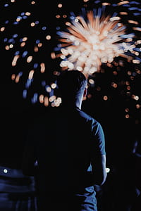 man watching fireworks during night time thumbnail