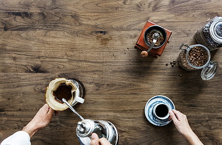 two person holding cups filled with coffee on table thumbnail