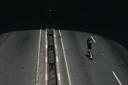 woman playing skateboard on asphalt road during daytime thumbnail