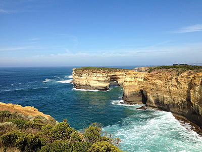 rock formation near body of water under blue sky thumbnail