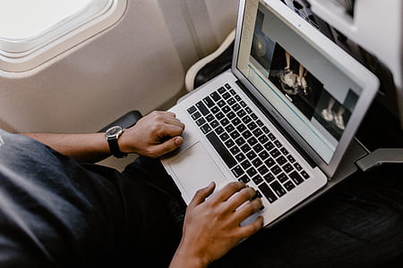 Unrecognizable man with notebook sitting inside an airplane thumbnail