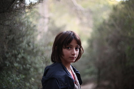 girl standing near green trees in closeup photography thumbnail