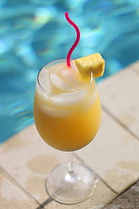 clear long-stemmed wine glass filled with yellow liquid thumbnail