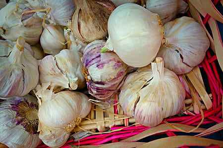 white and purple garlic cloves on brown wicker basket thumbnail