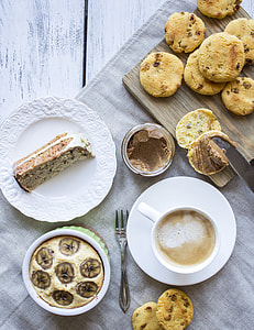 above ground photo of baked cookies on brown wooden chopping board beside teacup with coffee inside thumbnail