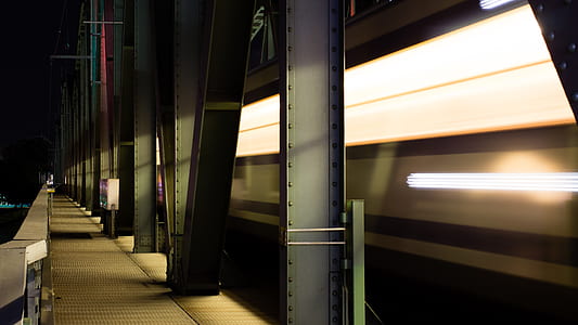 gray metal walkway with metal pillars during nighttime thumbnail