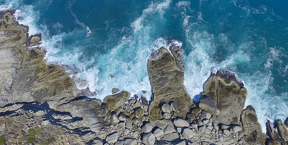 aerial photo of body of water and rock formation during daytime thumbnail