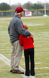 man holding girl on green grass field at daytime thumbnail