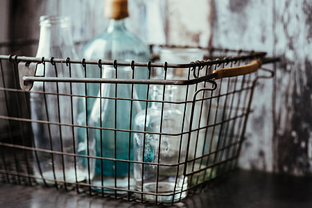 Collection of bottles in metal mesh basket thumbnail