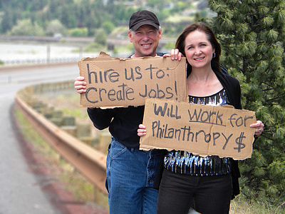 two person holding signage beside asphalt road thumbnail