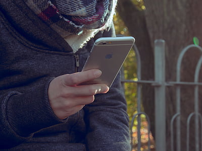 person in black jacket using silver iPhone 6 thumbnail