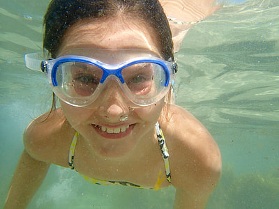 smiling girl swimming under water thumbnail
