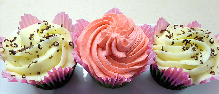 three pink and yellow cupcakes topped with chocolates thumbnail