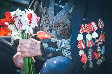 person holding flowers while wearing medals thumbnail