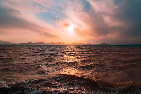 body of water under golden hour and cloudy sky thumbnail
