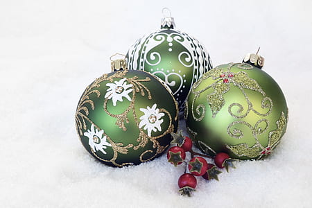 three green Christmas baubles on white surface thumbnail
