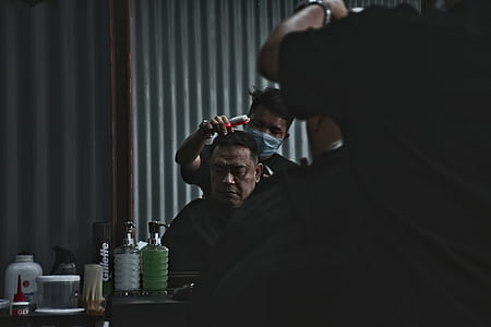 barber cutting man's hair in room thumbnail