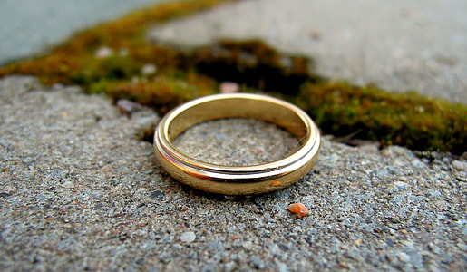 selective focus photography of gold-colored ring on concrete surface thumbnail