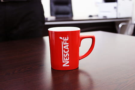 Red and White Nescafe-printed Mug on Brown Wooden Table thumbnail
