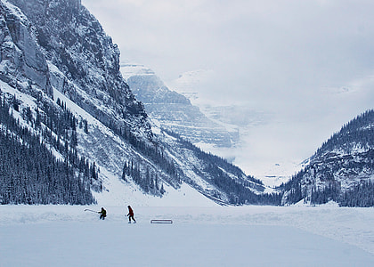 two person playing on snowfield near snow covered mountains at daytime thumbnail