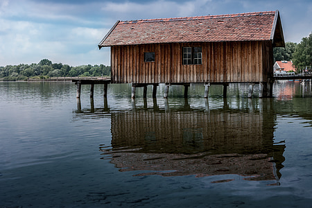 brown wooden house on body of water during daytime thumbnail