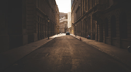 sepia photography of street in the middle of high-raise two buildings thumbnail