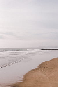 silhouette of person standing on seashore thumbnail