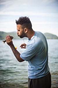 photo of man holding gray fish thumbnail