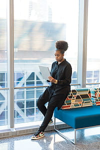 Woman in Black Jacket Standing Near Blue Sofa thumbnail