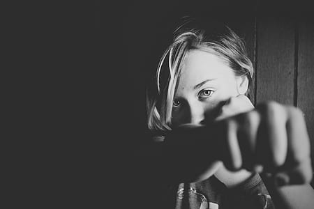 grayscale photo of woman leaning on black wall thumbnail