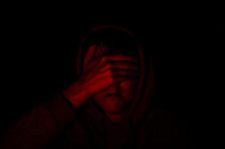 man wearing hoodie covering its face with hand thumbnail