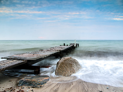 brown wooden dock beside body of water under white and blue sky thumbnail