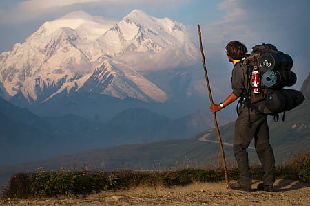 man in black shirt standing near mountain thumbnail