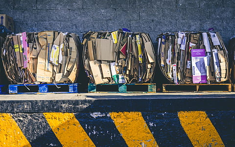 assorted-color cardboard box leaning on concrete wall thumbnail