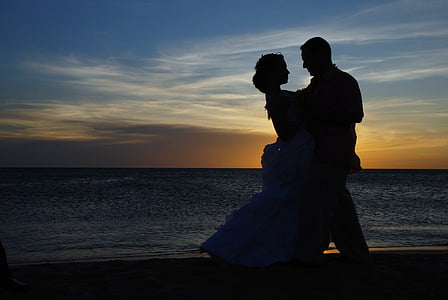 silhouette of dancing man and woman on shore during sunset thumbnail