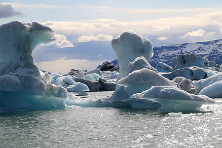 Mountain Covered With Snow Under over Body of Water during Daytime thumbnail