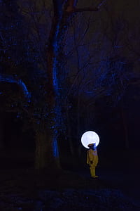 person wearing hazmat suit standing near tree thumbnail